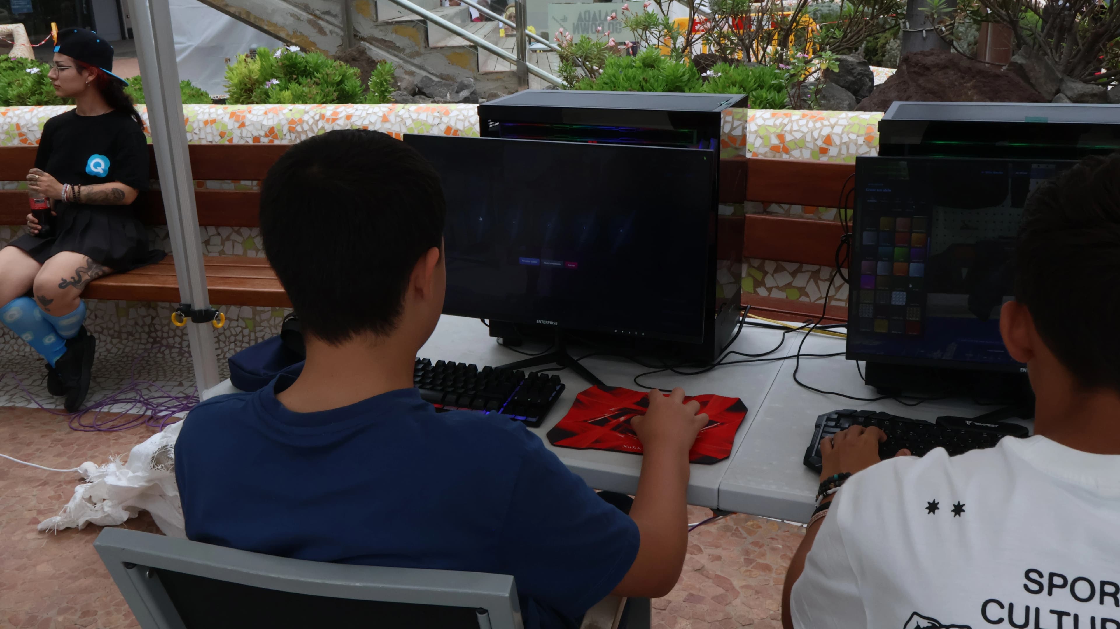 Attendees playing the Quasar Store FiveM Showcase server on gaming PCs at the booth